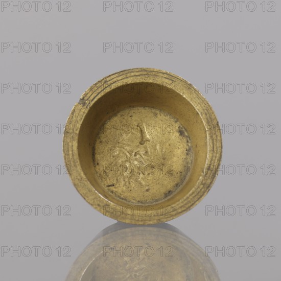 Gwicht, unknown creator; Roman Szewczykowski 1849–1901 provenance; In the shape of a truncated cone, marked inside 1; weight 12.8 g; 18th century; Europe, Germany, Berlin; height 0.9 cm; width 2.6 cm., A circular metallic cup-like object with a worn golden surface sits against a smooth light gray background, showing a textured interior and rim with concentric grooves and a few dark spots; the object casts a faint reflection below, and visible colors include gold, gray, and small areas of darker gray.