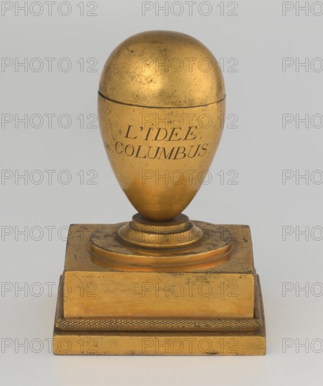 Inkwell, Tadeusz Bylewski 1866–1939, early 19th century, France, inkwell; height 13.5 cm, width 9.4 cm, depth 8.4 cm, A gold-colored ornamental object shaped like an egg on a stepped rectangular base, with a dome-like top and a rounded lower portion showing some surface wear and darker spots; the base and stepped platform share the same gold color and show areas of scuffing and darker discoloration, with a textured band around the lower edge of the platform; the background is a pale gray.