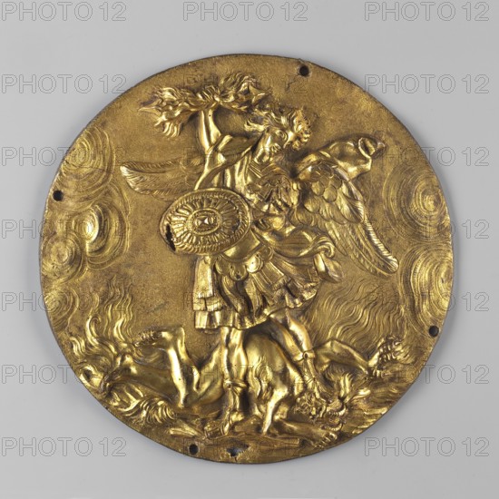 Circular plaque depicting the Archangel Michael with a gilded obverse. The Archangel in half-armor, with his torso tilted to the right, holds an oval shield in his left hand and a bundle of flaming arrows in his right. His left leg rests on the head of the lying Satan. Flames and clouds in the background. 1st half of the 17th century, Netherlands. Plaque; diameter 15.7 cm., A round metallic relief plaque with a golden finish shows a winged figure standing over a fallen figure; the standing figure wears a flared skirt and sandals, holds a circular shield in front, and raises an object above their head, while detailed wings extend from the back. The fallen figure lies beneath with limbs splayed and hair flowing. The plaque surface features swirling patterns and textured areas around the figures, and there are a few small holes near the rim. Visible colors include gold on the plaque and a pale gray background.