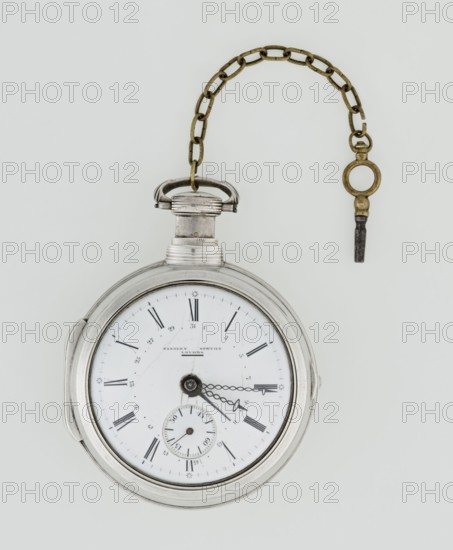 Pocket watch with key, Eardley Norton fl. 1770–1792 born 1728, died 1792. Two silver cases: smooth outer case and inner case with framed glazed lid. Mechanism cover engraved with an openwork floral twig, winding hole, and bell. White enameled dial with black Roman hour markers, minute scale marked with dashes, calendar with Arabic numerals, three steel hands hour and minute in openwork weave, third straight for days of the month, and small seconds subdial with Arabic numerals. Dial signed EARDLEY NORTON / LONDON. Movement with gilded brass circular plates connected by pillars, spring-powered drive, spindle escapement; lower plate with openwork crown richly decorated with acanthus tendrils and engraved acanthus volutes; cut-out reserve engraved Eardley / Norton London. Preserved winding key on a chain. Repeater mechanism. 3rd quarter of the 18th century; case probably Germany, movement London. Timepiece. Height 8 cm, width 6.2 cm, dial diameter 5.3 cm., A round pocket watch with a metal...