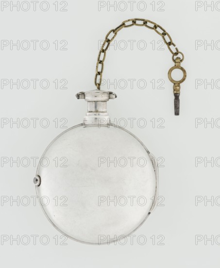 Pocket watch with key, Eardley Norton fl. 1770–1792; born 1728, died 1792. Pocket repeater in two silver cases: smooth outer case and inner case with framed glazed lid; mechanism cover engraved with an openwork floral/acanthus twig, with winding hole and bell. White enameled dial with black Roman hour numerals, minute scale marked with dashes, calendar with Arabic numerals, three steel hands hour and minute openwork weave, third straight for days of month, small seconds subdial with Arabic numerals. Dial signed EARDLEY NORTON / LONDON. Movement: gilded brass with circular plates connected by pillars, spring-driven with spindle escapement; lower plate with openwork crown richly decorated with acanthus tendrils and engraved acanthus volutes; cut-out reserve engraved with signature Eardley / Norton London. Preserved winding key on a chain. Casemaker Germany, 3rd quarter 18th century. Made in London. Timepiece. Height 8 cm; width 6.2 cm; dial diameter 5.3 cm., A round metallic object with ...
