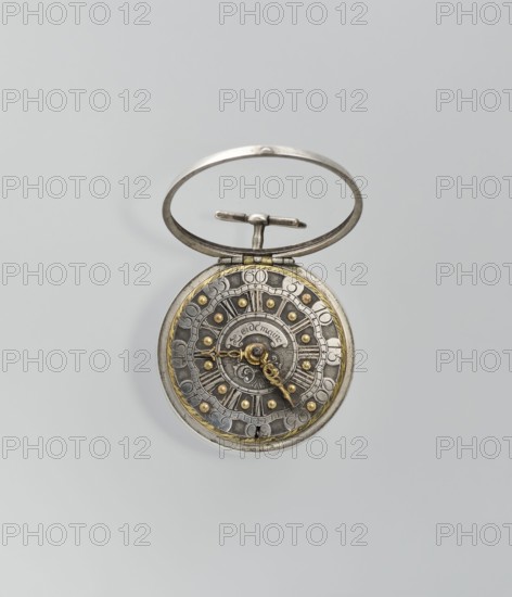 Pocket watch by Joseph Zeidlmayr fl. first half of the 18th century. Watch in a double case: outer case with a framed dial and a repoussé depiction of the Crucifixion with Mary and St. John on the back, surrounded by a border of eight C-shaped sections and ornamental decoration. Smooth silver inner case; silver dial with Roman numerals for hours separated by gold dots and Arabic minute numerals. Reserve bears the signature of the watchmaker Zeidlmayr. Inside, the movement cover has a cutout revealing a bun. Movement marked: Breslau / Joseph Zeidlmayr. On the inside of the case: a negative MS mark, a negative mark and a possible illegible goldsmith's mark rosette?, and two numbers—markings likely made by repair watchmakers. 1st half of the 18th century; Silesia; timepiece., An open pocket watch with a metal ring and hinge, showing a circular ornate face with metallic tones of silver and gold, a dark gray inner dial, and a few decorative raised studs in gold; the watch hands are intricat...
