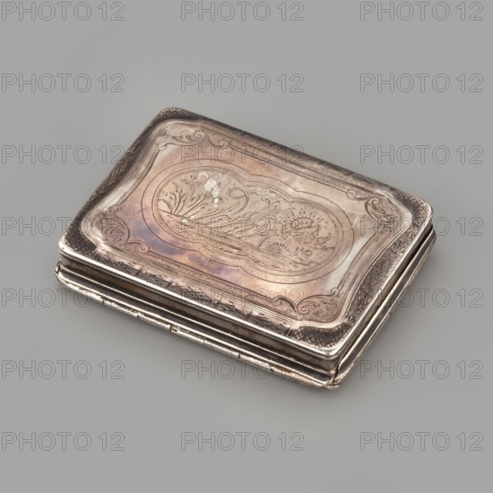 Snuffbox, rectangular, flat snuffbox with engraved decoration showing a squirrel and a rabbit in an elongated multi-leaf reserve and a geometric-floral border; on the bottom, an identical reserve with engraved flowers, a snail, and a bird. Materials: not specified. Subject motifs: animals squirrels, rabbits, birds, snails, flowers. Date: 1728–1729. Place of origin: Paris, France. Function: smoking accessory. Dimensions: height 1.6 cm; width 7.8 cm; depth 6.1 cm; weight 89 g. Provenance: scrap — purchase., A small rectangular metal case rests on a smooth grey surface, showing a tarnished silver finish with warm pinkish and purplish iridescent areas; the top has an engraved decorative border and a central cartouche with engraved floral motifs and flowing lines; the edges show slight wear and darker oxidized tones, and the folded hinge and layered sides reveal a polished metallic sheen contrasting with the aged patina.