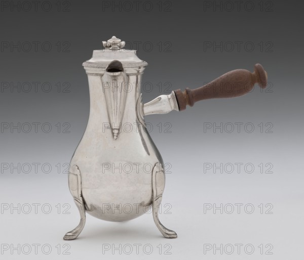 Coffee pot by Picard, F. fl. ca. 1798–ca. 1809. Silver vessel coffee pot, height 46.0 cm, width 8.5 cm, depth 8.5 cm, weight 248.2 g. Made in Paris, France, 1798–1809. Classified as tableware/coffee pot; associated with jugs and tableware items., A pear-shaped metal pot with a polished silver surface rests on a group of curved silver legs, featuring decorative vertical ridges and a spout near the top; a wooden handle with a warm brown color projects horizontally from one side, attached by a silver fitting, and a domed lid with a small ornamental finial tops the pot. The visible colors are silver, brown, and shades of gray in the background.