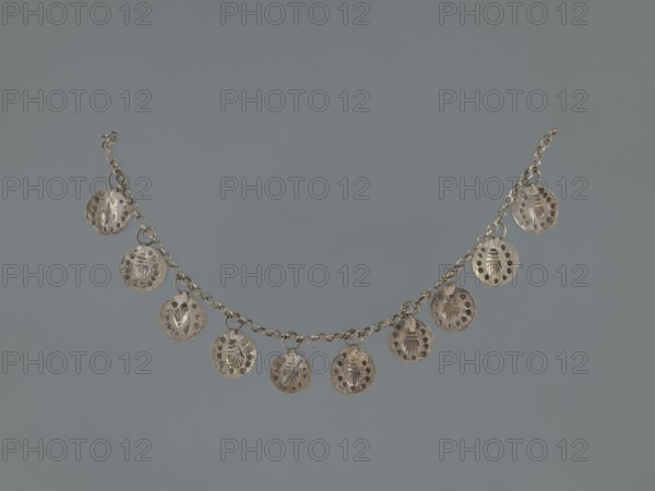 Bracelet, early 20th century, Middle East; Islamic art; shells; body and female ornament; hand ornament; fashion accessory; geometric ornament; length 27.0 cm., A silver-tone chain with a group of small round pendant discs evenly spaced along it, each disc having a central raised motif and a ring of perforations around the edge, shown against a plain muted bluish-gray background; colors visible include silver and bluish-gray.