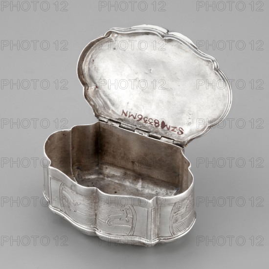 Snuffbox on an oval plan with irregular edges, vertical ribbed walls; on the lid a depiction of dogs tracking hares among channel sections; on the side walls in the reserves a dog tracking a hare, a goose, and plant ornaments. Materials: scrap. Subject: animals, hares, dogs, hunting scenes, dogs tracking game, geese. Function: smoking accessory. Date: 1756–1762. Place of origin: Paris, France. Dimensions: height 4 cm, width 8.4 cm, depth 5.3 cm., A small open metal box with a scalloped lid and a matching scalloped base sits against a plain neutral background; the interior shows a duller metal finish while the exterior has a shinier silver appearance and engraved decorative panels depicting animal figures, and there are traces of darker tarnish inside and a few small spots of reddish discoloration on the lid and rim.