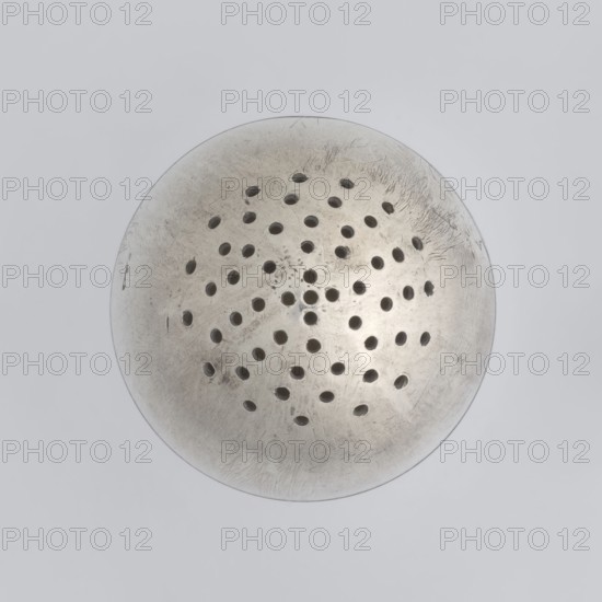Salt cellar;, scrap - purchase; spices vessel; salt vessel; spice vessels; 19th century; St. Petersburg, Russia; vessel; height 4 cm; width 3.1 cm, A circular metallic object with a slightly domed surface and a weathered, scratched texture, featuring a pattern of several small round perforations arranged across its central area; the metal shows tones of silver, gray, and muted off-white with darker shadowed holes, all set against a pale gray background.