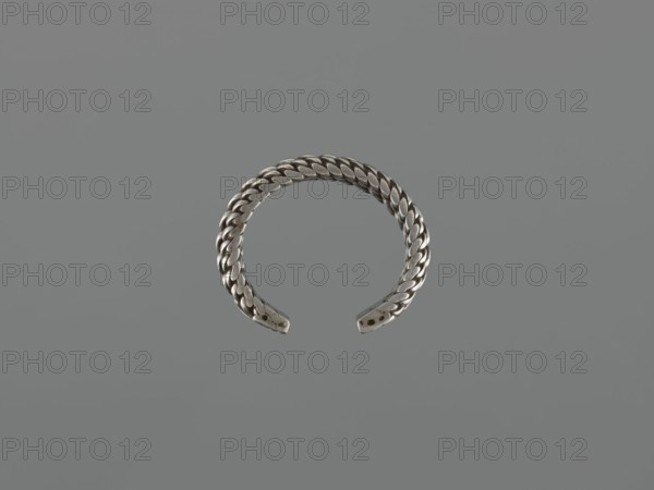 Bracelet, 19th century, Middle East, tugra motif; Islamic art; body/female/hand ornament; fashion accessory; materials: jewelry; height 2.5 cm, width 7.0 cm, weight 170 g., A braided metal cuff bracelet with an open end displayed against a uniform gray background; the bracelet appears silver in color with a woven texture and slightly darker shadows along the braided links and the ends of the cuff.