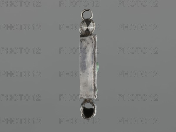 Ga'u box fragment, maker, plant twig, jewelry; Himalayan culture; Tibetan Buddhist art; amulet; Tibetan; provenance, 19th century, Tibet; varia; height 11.0 cm; width 7.5 cm; weight 125 g, A vertically oriented metallic object with a rectangular central body and decorative rounded ends, shown against a uniform gray background; the metal appears silver with areas of darker tarnish and subtle scratches; the top end has a faceted spherical element with a loop, both silver-colored with beaded edging, and the bottom end has a hollow oval opening framed by beaded silver; along one long edge there is a narrow beaded border and a few small rounded green elements partly visible.