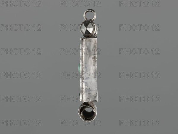 Ga'u box - fragment, plant twig, jewelry, Himalayan, Himalayan art, Tibetan Buddhist art, amulets, Tibetan culture, provenance unknown, 19th century, Tibet, varia, height 11.0 cm, width 7.5 cm, weight 125 g, A vertical silver metallic pendant photographed against a neutral gray background, with a rounded loop at the top and a hollow cylindrical element at the bottom, a faceted spherical bead near the top, an elongated rectangular centralplate with a slightly worn surface and beaded edging on one side, small rounded green stones set along the side, and visible textures and reflections on the metal showing areas of polish and subtle tarnish in colors including silver, gray, green, and dark metallic tones.