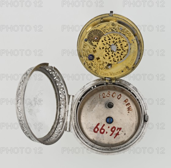 Pocket watch by Carl Willougby, second quarter of the 18th century London, England. Silver, partially openwork case richly engraved with acanthus twigs, flowers, birds, two masks male and female, acanthus scrolls, fish-scale ornament, shells; glazed lid enclosed by an openwork frame decorated with a floral twig and a broken ribbon. In the center a circular reserve of acanthus twig, volutes and fish scales, inside a bell. Pocket watch with striking function; mechanism between two circular plates supported by columns, with spindle escapement, a worm with a chain, and a balance drum. Gilded, openwork crown with engraved acanthus twig combined with an openwork foot and a woman's mask. White-enamel dial edged with a gilded, knurled ribbon; hour markers in Arabic numerals, minutes marked with vertical lines; steel hands. Height 8 cm, width 5.5 cm, dial diameter 4.5 cm., An open metal pocket watch with an ornate hinged case and an exposed inner mechanism; the top interior shows a decorative c...