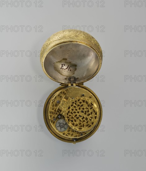 Pocket watch by Jacques Marcet fl. ca. 1725–ca. 1750. Gilded silver pocket watch, almost spherical, in a double case; enameled numerals on the dial. Cases decorated with plant decoration: inner case with flowers in a vase in a reserve formed by a ribbon that on the outer side forms heart-shaped loops with floral sprigs between them. A strip of plant-floral tendrils on the side of the case. Outer case with a flower sprig in a circular central reserve surrounded by an interwoven ribbon and floral sprigs in the fields. Movement signed Jacques/Marcet and has an openwork bow. Inside both cases engraved number E. 4 unidentified. Engraved case decoration stylized in a Middle Eastern style; possibly intended for the Turkish market. Watchmaker uncertain; possibly worked in England if a Huguenot. 2nd quarter of the 18th century, France . Timepiece. Dimensions: height 6.5 cm, width 5.5 cm, depth 4 cm. Style: classicism; decorative vases; flowers., A round, opened metal object with ornate, carved ...