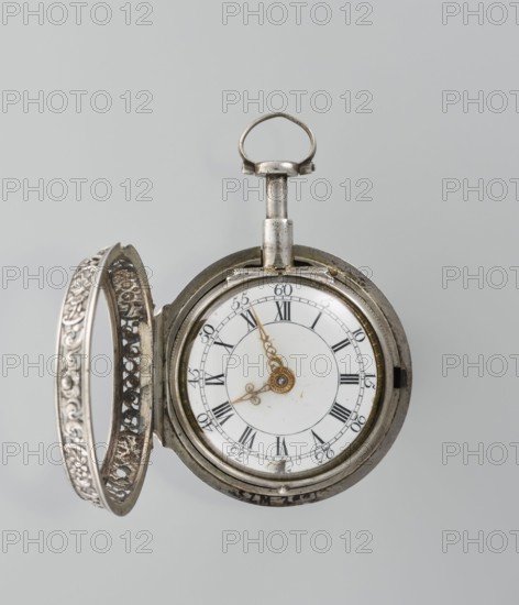 Pocket watch by Shart, signed on the movement Shart / London, 1730s. Double silver case; inner case openwork with Regency motifs. Outer case repoussé depicting Diana hunting, surrounded by an openwork border with male and female busts. White enamel dial with Roman hour numerals and Arabic minute numerals, openwork hands. Timepiece, height 6.8 cm, width 4.8 cm. Located in London, England, Great Britain., A round pocket watch with its ornate hinged cover open, showing a white circular dial with decorative gold hands and a central gold ornament; the watch case and cover are silver with intricate filigree and floral patterns, and the winding crown and loop at the top are also silver; the visible colors are silver, white, and gold against a pale gray background.