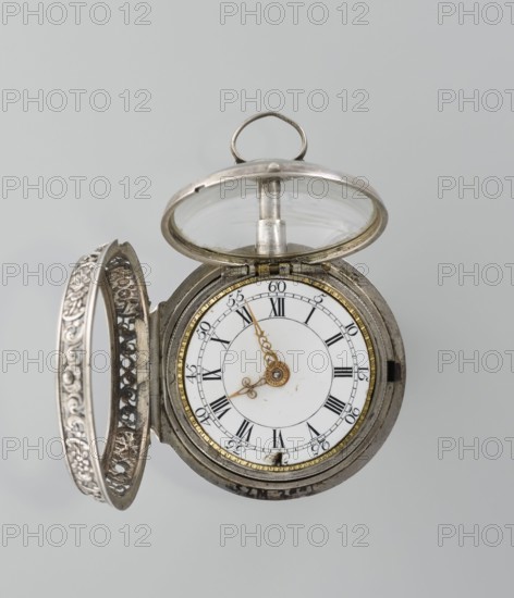 Pocket watch by Shart signed on the movement: Shart / London, 1730s, London, England. Pocket watch in a double silver case; inner case openwork with Regency motifs; outer case decorated with a repoussé scene depicting Diana hunting, surrounded by an openwork border with male and female busts. White enamel dial with Roman numerals for hours and Arabic minutes, openwork hands. Height 6.8 cm, width 4.8 cm., A close-up of an open pocket watch showing a metallic outer case and hinged cover with intricate floral filigree; the watch face is white with black markings and ornate gold-colored hands, surrounded by a thin gold-toned inner ring and a silver-toned outer casing, with a clear glass protective lid propped open and a small circular metal loop at the top; visible colors include silver, white, gold, black, and clear glass.