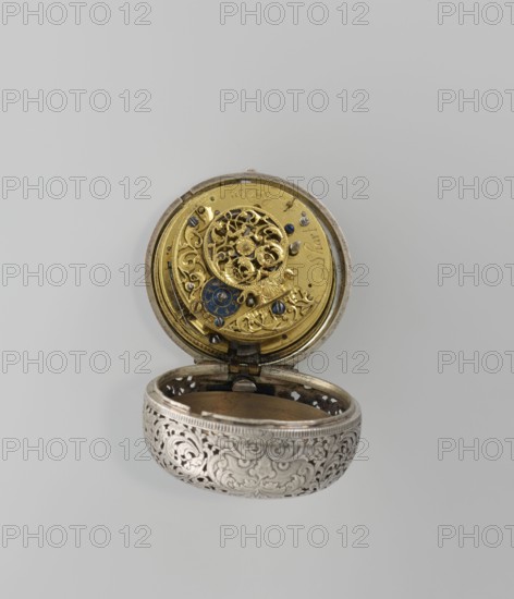 Pocket watch by Shart signed on the movement: Shart / London, 1730s, London, England. Pocket watch in a double silver case; inner case openwork with Regency motifs; outer case repoussé scene depicting Diana hunting surrounded by an openwork border with male and female busts. White enamel dial with Roman numerals for hours and Arabic minutes, openwork hands. Timepiece; height 6.8 cm, width 4.8 cm., An open ornate pocket watch with a silver outer case featuring intricate raised floral and scrollwork patterns, and an inner gold-toned mechanism visible in the top half with decorative filigree and several small blue-tinted screws and components; a small blue circular element is set among the gold gears, and the hinge connecting the two halves is visible; the background is a pale light gray.