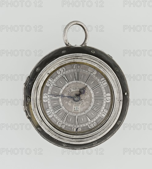 Pocket watch by John Bushman 1692–1720. Silver pocket watch in three cases: outer case covered with leather, rim decorated with studded silver rosettes; middle and inner cases plain. Underside of inner case stamped with casemaker's initial H and number 3081. Transparent lid. Silver champlevé dial with Roman numeral hour markers and Arabic minute markers in oval reserves on a matte background; central circular reserve with the watchmaker's signature on two semicircular plates reading BUSHMAN and LONDON; date window at the bottom. Steel hands with openwork hour hand. Movement with plate skeleton, spring drive, worm gear, and Gall chain; spindle escapement. Gilded lower plate with openwork English-style bun in the form of a wreath filled with acanthus tendrils and openwork grid, connected by a mascaron mask with an openwork bun foot. Hair adjustment is a rotating silver-plated dial with scale I–VI. Engraved on the plate in italics: Jn Bushman 3081 / LONDON. Circa 1700, London, England. Ti...