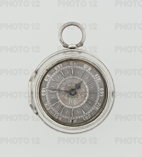 Pocket watch by John Bushman 1692–1720, c. 1700. Silver pocket watch in three cases: outer leather-covered case with studded silver rosettes on the rim; plain middle and inner cases. Underside of inner case engraved with casemaker's initial H and number 3081. Transparent lid. Silver champlevé dial with Roman hour numerals and Arabic minute markers in oval reserves on a matte background; central circular reserve with the watchmaker's signature on two semicircular plates reading BUSHMAN and LONDON; date window at the bottom. Steel hands with openwork hour hand. Movement with plate skeleton, spring drive, worm gear, and Gall chain; spindle escapement. Gilded lower plate with openwork English-style bun in the form of a wreath filled with acanthus tendrils and an openwork grid, connected by a mascaron mask with an openwork bun foot. Hair adjustment is a rotating silver-plated dial numbered I–VI. Plate engraved in italics: Jn Bushman 3081 / LONDON. Timepiece from London, England. Dimensions:...