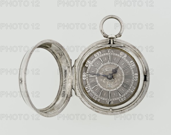 Pocket watch, Bushman, John 1692–1720 watchmaker. Silver pocket watch in three cases. Outer case covered with leather, decorated on the rim with studded silver rosettes; middle and inner cases plain; on the underside of the inner case the casemaker's initial H and the number 3081; transparent lid. Silver champlevé dial with Roman numeral hour markers and Arabic minute markers in oval reserves on a matte background; central circular reserve with the watchmaker's signature in two semicircular plates reading BUSHMAN and LONDON; date window at the bottom. Steel hands, openwork hour hand. Movement with a plate skeleton, spring drive, worm gear, and Gall chain. Spindle escapement. Gilded lower plate with an openwork English-style bun in the form of a wreath filled with acanthus tendrils and an openwork grid, connected by a mascaron mask with an openwork bun foot. Hair adjustment in the form of a rotating silver-plated dial with a scale of I–VI. Engraved on the plate is the watchmaker's signa...