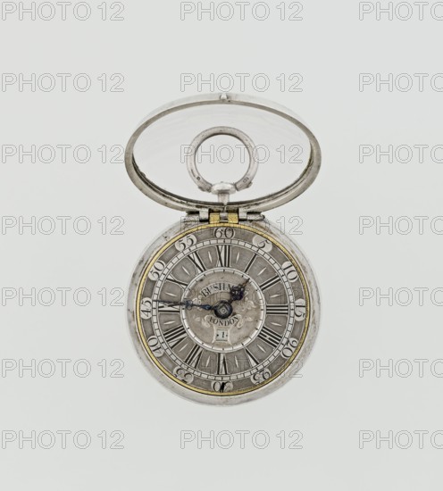 Pocket watch by John Bushman 1692–1720. Silver pocket watch in three cases: outer case covered with leather and decorated on the rim with studded silver rosettes; middle and inner cases plain. On the underside of the inner case the casemaker's initial H and the number 3081. Transparent lid. Silver champlevé dial with Roman numeral hour markers and Arabic minute markers in oval reserves on a matte background; central circular reserve with the watchmaker's signature in two semicircular plates reading BUSHMAN and LONDON; date window at the bottom. Steel hands with openwork hour hand. Movement with a plate skeleton, spring drive, worm gear, and Gall chain. Spindle escapement. Gilded lower plate with an openwork English-style bun in the form of a wreath filled with acanthus tendrils and an openwork grid, connected by a mascaron mask with an openwork bun foot. Hair adjustment as a rotating silver-plated dial with a scale I–VI. Engraved on the plate in italics: Jn Bushman 3081 / LONDON. Circa...