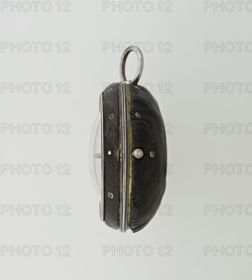 Pocket watch by John Bushman 1692–1720. Silver pocket watch in three cases: outer case covered with leather and decorated on the rim with studded silver rosettes; middle and inner cases plain. Underside of the inner case stamped with casemaker's initial H and number 3081; transparent lid. Silver champlevé dial with Roman numeral hour markers and Arabic minute markers in oval reserves on a matte background; central circular reserve with the watchmaker's signature in two semicircular plates reading BUSHMAN and LONDON; date window at the bottom. Steel hands with openwork hour hand. Movement with a plate skeleton, spring drive, worm gear, and gall chain; spindle escapement. Gilded lower plate with an openwork English-style bun in the form of a wreath filled with acanthus tendrils and an openwork grid, connected by a mascaron mask with an openwork bun foot. Hair adjustment as a rotating silver-plated dial with scale I–VI. Engraved on the plate in italics: Jn Bushman 3081 / LONDON. Circa 170...