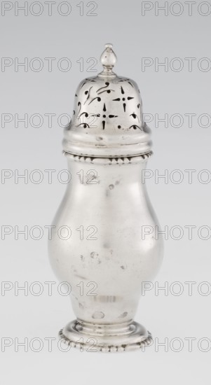 Powdered sugar bowl, powdered sugar bowl with domed openwork cover topped with a bowl; pear-shaped powdered sugar bowl on a circular profiled foot, with a domed openwork cover topped with a bowl. Openwork, sugar vessel, astargal ornament. Maker: Burbidge, Richard 1847–1917, goldsmith. Manufacturer/seller: Harrod's Stores Ltd London, fl. from 1849. Date: 1913/1914. Place: London, England. Form: dish. Dimensions: height 15 cm; diameter 5.9 cm; weight 152 g. Purchase provenance: scrap — purchase., A single metallic container with a rounded body and a removable perforated domed lid sits against a plain light background; the object is primarily silvery with areas of darker tarnish and small spots, the lid shows decorative cutout patterns and a small finial on top, the body tapers toward a stepped circular base that has a beaded edge, and the overall surface displays slight scratches and blemishes in shades of silver and gray.