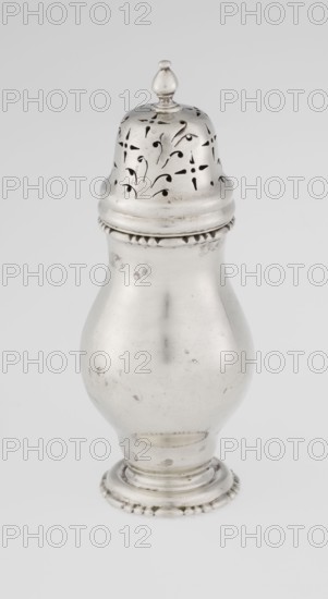 Powdered sugar bowl, powdered sugar bowl with domed openwork cover topped with a bowl; pear-shaped body on a circular profiled foot; edge of foot and top rim decorated with astargal; openwork; sugar vessel; dish. Maker: Harrod's Stores Ltd London; sellers; fl. 1849-; goldsmith: Richard Burbidge 1847–1917 Managing Director at Harrods. Date: 1913/1914. Place: London, England, Great Britain. Function: sugar. Materials/technique: openwork metal. Dimensions: height 15 cm; diameter 5.9 cm; weight 152 g. Purchase provenance: scrap — purchase., A single metallic object with a pear-shaped body and a domed, perforated top capped by a small finial sits against a plain light background; the object appears silver in color with a slightly tarnished, reflective surface showing small marks and scuffs, a beaded decorative band near the base and another textured band beneath the top, and the perforations on the top form small curved and teardrop-shaped openings revealing dark interior contrast.