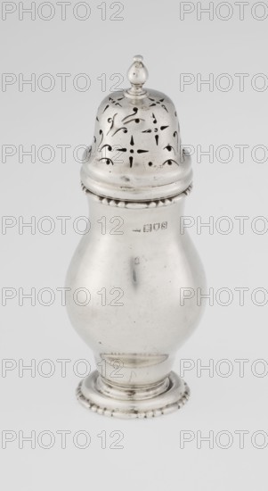Powdered sugar bowl, Harrod's Stores Ltd London; maker/seller, fl. 1849-, maker: Richard Burbidge 1847–1917 goldsmith Managing Director at Harrods. Pear-shaped powdered sugar bowl on a circular profiled foot, with a domed openwork cover topped with a bowl. Edge of the foot and the top rim decorated with astragal. Openwork; sugar vessel; dish. Date: 1913–1914. Place: London, England. Height 15 cm; diameter 5.9 cm; weight 152 g., A single metallic object with a reflective silver surface stands upright against a light gray background, featuring a domed lid with decorative perforations and a small rounded finial on top, a bulbous midsection with a smooth curved profile, a narrow neck with a beaded rim, and a flared circular base with a beaded edge; visible colors are silver, light gray, and small darker gray reflections on the metal.