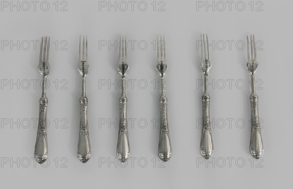 Six fruit forks by Adam Nagalski 1862–1944, 1915–1920, Poland, Warsaw; cutlery; height 16.5 cm, width 1.8 cm, A row of several ornate metal forks is laid out against a pale gray background, each fork showing a shiny silver finish with decorative engraved handles featuring floral and scroll motifs; the tines and necks of the forks are slender and polished, and the overall colors visible are shades of silver and gray.