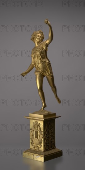 Candlestick, lyre and swans iconography, 19th century, Paris, France, lighting, height 54 cm, A gilded statue of a youthful figure standing on a decorated square pedestal, the figure shown in a dynamic pose with one arm raised and the other extended, wearing a textured draped garment and with curly hair, the surface appearing metallic gold; the pedestal is also gold with ornate carved relief panels and a stepped base, all set against a plain gray background with soft lighting.