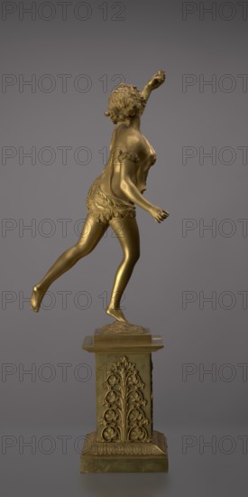 Candlestick, lyre iconographic, swans iconographic, 19th century, Paris, France, lighting, height 54 cm, A golden-colored statue of a female figure poised on a decorated pedestal, shown in profile with one arm raised and the other extended slightly forward; the figure has short curly hair and wears a textured skirt and fitted top with decorative bands on the upper arms, with one leg extended backward and the other foot resting on the pedestal; the pedestal is also golden-colored and features ornate vertical floral reliefs and a stepped base; the background is a smooth gray.
