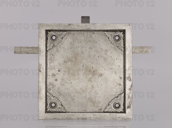 Square-faced door lock with latches and key, made by Michal Taszynski fl. 1820–1838. Dated 1861. Precisely crafted steel lock distinguished by protruding side bolts latches that lock the door simultaneously in three directions—top, bottom, and middle. Ornamentation on the top features a light pattern. Mechanism: resting bolt with two heads and a latch bolt between them that opens with a half-turn; a full turn of the key activates the double bolt and locking mechanism. Neat workmanship. Inside the box, on the side, a hallmark is stamped twice—a striding figure with a large key likely a striding bear with a key, styled like a 19th-century city coat of arms. Attributed to Michal Daniel Taszynski born 1836, son of Michal Taszynski, a locksmith specializing in polished steel accessories. Dimensions: height 16.1 cm, width 15.8 cm, depth 6.9 cm., A square metallic plate with a raised border and a recessed central panel showing surface wear and small blemishes, each corner of the inner panel d...