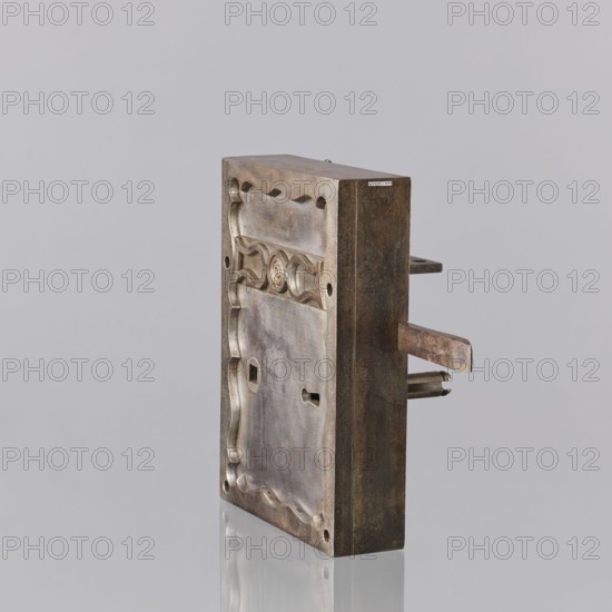 Vault lock, Konstabel, Karol maker: locksmith, Masterpiece of the late Karol Konstabel, Guild Master, marked with the guild stamp. The lock's cabineting and workmanship, along with the key register, are among the more outstanding features. The lock has three bolts and a fourth latch bolt connected to the handle, which is missing. The cup is rectangular, with a border overlaid on it with an inner wavy edge, and a three-length vertical strip with a sequin and two inverted lyre shapes. On the underside, the case with the mechanism is separated, with a narrow chamber that was supposed to cover the bolt hasps. The stamp mentioned by Szewczykowski is invisible. The same technical solution as in a handmade lock described as Taszynski's from 1861 suggests it was a typical masterpiece lock presented in Warsaw and, as described in the Crafts Act of 1816, a precise treasury lock for a main door with flanking riffles with two springing and two lifting fels. Schierkapa with pasquil. Karol Konstabel...