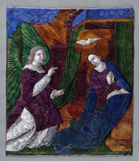 Plaque - Annunciation Scene; creator, Mary mother of Jesus Christ; Annunciation New Testament; Archangel Gabriel iconography; Dove of the Holy Spirit iconography; 19th century, Limoges, France; enamel plaque; height 18.6 cm, width 16 cm, A painted scene shows two human figures facing each other inside a draped interior; a winged figure on the left wears a purple robe with white sleeves and has large green wings and pale skin with light brown hair, while the figure on the right kneels on a blue cloak and wears a purple top with a deep blue outer garment, pale skin, and reddish-brown hair, hands held near the chest; above the kneeling figure a white bird with outstretched wings is surrounded by radiating golden-orange light; the background features green curtains and a reddish-brown patterned wall with beams of golden-orange light and a strip of deep blue decorated border along the top, and the floor area shows brown and green tones with a raised architectural element at the lower right.