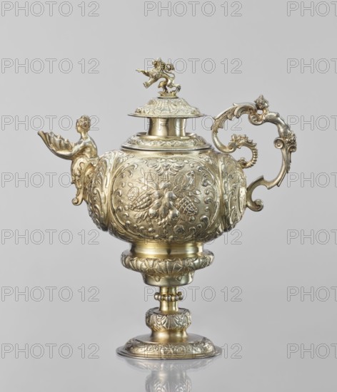Water tincture, Schweiger, Matthias fl. ca. 1623–1635, goldsmith; herms decorative elements; lions; flowers ornament; fruit ornament; acanthus ornament. Jug with a spherical belly decorated with repoussé bouquets of flowers and fruit in acanthus reserves; on the side a spout in the shape of a female half-figure holding a conch; on the axis a plastic handle formed of channel sections connected by a winged herm of a woman. The cover is topped with a plastic lion standing on its hind legs. 1630–1635, Augsburg, Germany. Vessel; height 28 cm, width 14 cm, depth 30 cm., A single ornate vessel with a lid and pedestal is shown, rendered in a metallic gold color with areas of lighter and darker gold tones; the body is rounded and richly decorated with embossed floral and scroll motifs, and the surface has a reflective sheen. The lid is topped by a small sculpted figure of a lion in the same gold color, and the spout area features a sculpted figure of a partially visible human form holding a she...