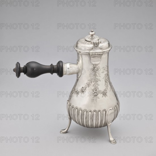 Chocolate jug, maker: Edme-Pierre Balzac fl. 1739–1781, goldsmith. Pear-shaped chocolate jug supported on three legs, with a small spout and a hinged lid featuring a circular opening and a sliding circular cover. The lower part of the belly is decorated with vertical curls; the upper part with repoussé garlands and an oval reserve. Material: metal goldsmith work. Date: 1764–1765, place of origin: Paris, France. Dimensions: height 26 cm, width 24 cm, depth 13.5 cm., A metal pot with a rounded body and decorative engraved floral garlands stands on three curved legs; it has a hinged domed lid with a small finial and a strap-like hinge, and a turned dark wooden handle projecting from the side. The visible colors are silver on the metal body and lid, dark brown to black on the wooden handle, and a pale gray background.