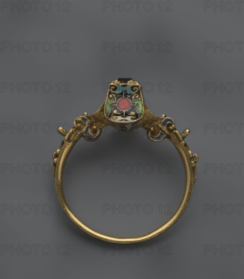 women's ring, 19th century, Poland, jewelry, height 2.4 cm, width 2.1 cm, A gold ring viewed from above showing its circular band and an ornate setting with cloisonné-style enamel decoration; the band is metallic gold and slightly textured, the setting features a shield-like top with enamel areas in green, blue, white, and a central red circular element, and there are additional small enamel accents in blue and red on the decorative shoulders, all against a neutral gray background.