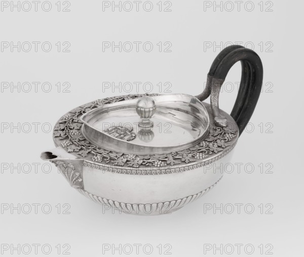 Teapot, Rundell Bridge & Rundell fl. ca. 1788–1845 goldsmith's firm, Scott, Digby & Smith, Benjamin fl. 1802–1807 goldsmith's firm; vines, snake iconography; Pogon Ruska coat of arms; purchase provenance; tea vessel; coats of arms; tea vessel; rank crowns; princely mitre / heraldry; mottos heraldry; paludamentum heraldry; acanthus leaves ornament; clasp; labry heraldry. Hemispherical, on a low cylindrical pedestal, body decorated in the lower part with radial curls, at the upper edge with a band of acanthus leaves; a hinged lid surrounded by a raised collar with an applied vine branch with clusters; a double handle of blackened wood set in caps upper caps shaped as snake heads, lower as tails; the Czartoryski coat of arms applied on a paludament with labry and the motto Badz co sie jest. 1803–1804, London, England, Great Britain. Vessel; height 13 cm, width 24.6 cm, depth 17.2 cm, weight 1002 g., A silver teapot with a rounded body and decorative banding sits against a plain light gray...
