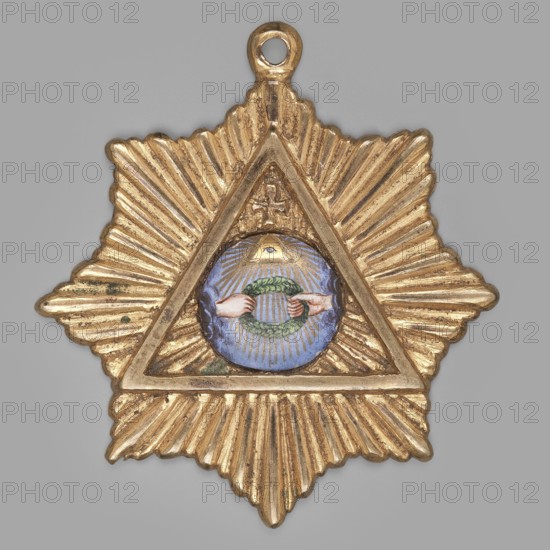 Badge of the lodge zur Einigkeit, Gdansk, freemasonry; masonic lodge emblem; laurel wreaths; triangle Masonic emblem; radiant eight-pointed star with a triangle at center containing an enameled circle surmounted by a cross; in the circle on a purple background two hands holding a wreath; in the triangle the Eye of Providence within rays; reverse with lodge initials ZE; ring for hanging on a ribbon; ca. 1880; Poland; material: masonry; height 5.8 cm, width 5.5 cm., A star-shaped metallic pendant with a radiating ridged texture in gold tones, featuring a triangular frame at its center. Inside the triangle is a circular enamel area in shades of blue with a pair of hands in flesh tones holding a green wreath, and a small triangular motif above the wreath with gold rays emanating outward. The pendant has a small loop at the top in the same gold color.