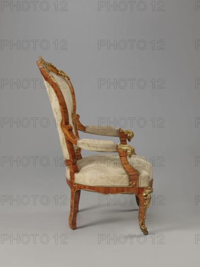 Armchair, origin unknown, rocaille ornament, neo-Rococo style, decorated with flowers, acanthus ornament, fêtes galantes, campanulas, floral bouquets, cartouches. Neo-Rococo armchair, upholstered backrest, seat, armrests, veneered with rosewood, decorated with porcelain plaques and cast brass fittings. S-shaped legs widening in the upper section cabriole, arching into a frame with a wavy outline, bulging; front ends with rollers. Armrests repeat the frame outline, on recessed, slightly S-shaped supports, topped with volutes. Backrest in the form of a symmetrical cartouche, widening upwards, framed by channel sections topped with volutes; with a clearance. Center of the front frame and backrest finial feature porcelain plaques painted with flowers, framed by a brass frame composed of rocaille, flowers, and acanthus leaves. Edges of the frame accented with brass strips; brass fittings include a garland at the backrest finial, volutes at the end of the armrest, acanthus plaques and slippe...