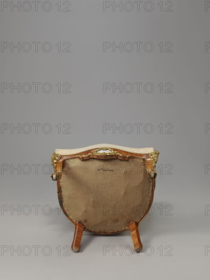 Armchair, origin unknown, neo-Rococo rocaille ornament, decorated with flowers, acanthus, fetes galantes, campanulas, and floral bouquets; veneered with rosewood, with porcelain plaques and cast brass fittings. Upholstered backrest, seat, armrests; seat on springs; upholstery non-original, with lace ribbons featuring floral bouquets. Form: S-shaped cabriole legs widening in the upper section and arching into a wavy, bulging frame ending with rollers at the front. Armrests repeat the frame outline on recessed, slightly S-shaped supports topped with volutes. Backrest shaped as a symmetrical cartouche widening upward, framed by channel sections topped with volutes and a clearance. Porcelain plaques painted with flowers set in brass frames of rocaille, flowers, and acanthus leaves at the center of the front frame and backrest finial. Edges accented with brass strips; additional brass fittings include a garland at the backrest finial, volutes at the armrest ends, acanthus plaques, and slipp...