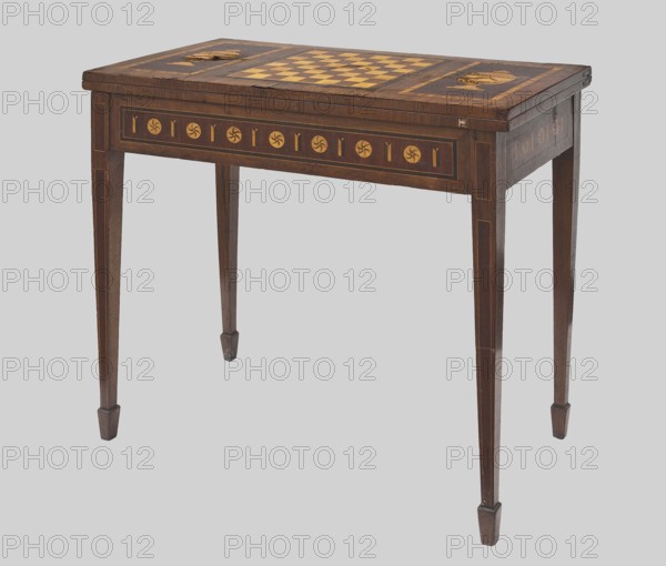 Game table, games, classicism style, rosette ornament, chessboards, vases, classicist. Rectangular game table, square when unfolded, supported by four angular, converging legs with wedge feet; veneered and inlaid. The top is divided into three rectangular fields, enclosed by a ribbon and two veins, filled with vases outermost and a chessboard. 18th/19th century, Central Europe; possibly Gdansk. Furniture; game furniture. Height 77 cm, width 42.5 cm, depth 86 cm., A wooden table with a rectangular top featuring an inlaid checkered pattern in lighter and darker wood tones and decorative circular inlays toward each end, supported by four tapered legs with simple square feet; the table surface and legs show grain and wear, and the visible colors are brown and lighter tan against a pale gray background.