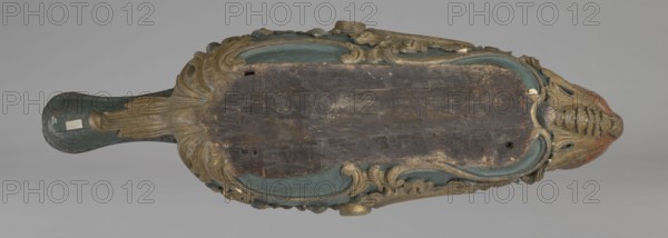 Sleigh, rococo two-seater, carved, polychrome, gilded; 3rd quarter of the 18th century, Poland . The sleigh is in the shape of a gondola made using the dugout canoe method, painted blue, with a wavy upper rim highlighted by a half-cylinder and channel sections with rocaille motifs. Front fashioned as a mascaron painted red, framed with acanthus leaves; rear has a trestle originally upholstered with a carved acanthus beneath. Inside the sled are four sockets for connection with skid supports. Subjects/ornament: mascarons, men's heads, rocaille, acanthus. Height 57 cm; width 208 cm; depth 68 cm., An elongated carved wooden object viewed from above with ornate scrollwork and a handle, showing a worn dark brown central surface surrounded by carved raised borders in muted teal and gold tones, with areas of faded reddish-brown and natural wood peeking through; the carving includes flowing leaf-like forms and rounded protrusions, and the handle end is darker teal with small lighter patches an...