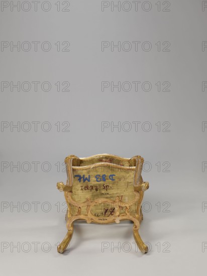 Side table, equipment of representative buildings of the Republic of Poland 1918–1939, unknown origin, plant decoration, acanthus ornament, volutes, neo-rococo style, 3rd quarter of the 19th century, Warsaw, furniture — table; height 77.3 cm, width 50 cm, depth 40 cm., A small ornate chair shown from the back with a carved frame and curved legs, featuring a worn gold finish with areas of exposed wood tones and touches of muted pink; the background is a smooth light gray and the floor is a slightly darker gray.