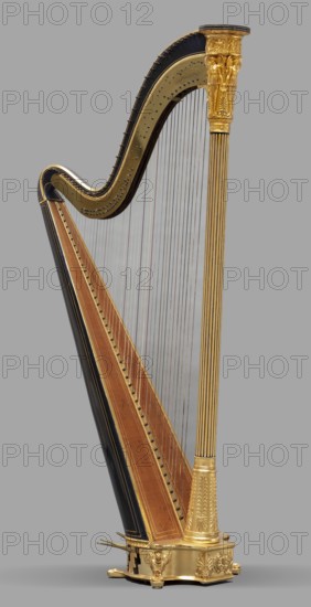 Two-stage pedal harp, Erard London; musical instrument manufacturer; 1792- and Erard Paris; musical instrument manufacturer; 1780- co-creator. Two-stage pedal harp, 43-stringed, Empire style, carved, gilded, and polychromed. The column is a fluted form topped with a capital tapering downward with applied plaster-modeled decoration: at the top a frieze with winged figures holding straight trumpets and lyres; below, three caryatids with wings and wreaths, between them palmettes, rosettes, and pearls. The arm is S-shaped, painted indigo with gold-painted veins. The soundboard tapers upward, rounded at the back, painted indigo with double gilded frames, and a spruce top. The semicircular base, on low legs with carved necks, with palmettes and a female head in a wreath on the front, houses seven brass two-step pedals for tuning and one single-step pedal for opening the sound holes. Dated 1829, London. Musical instrument. Height 170.5 cm; width 44 cm; depth 80 cm., A tall ornate harp stands ...