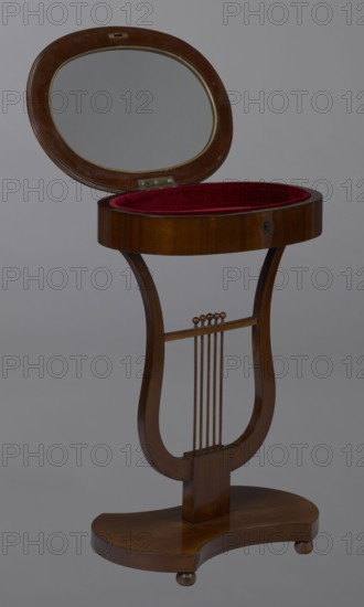 Oval display table with a lyre-shaped base mounted on a platform with a concave–convex outline, supported by four spherical legs. Veneered with mahogany. Lyre strings terminate at the top with balls. The edge of the tabletop frame is profiled. 1820–1840, Central Europe. Piece of furniture for displaying objects. Dimensions: height 76.7 cm, width 52.3 cm, depth 37.9 cm., A wooden stand with a lyre-shaped frame supporting an oval top with its lid open to reveal a plush red interior, the lid featuring an inset oval mirror; the wood is a warm brown with a polished finish, and the base is a curved wooden platform with small rounded feet.