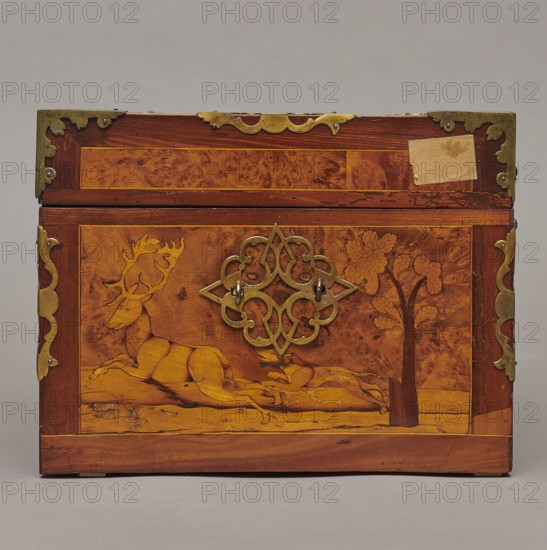 Casket, Repossession provenance. Sleigh, deer, hunters, hounds, riders. Baroque style. Cuboid case inlaid with figural scenes, with openwork brass fittings. Front wall of the body shows a deer hunt with dogs; lid has an oval field depicting a sleigh drawn by a deer. Interior: under the chamber floor are three drawers middle one smaller accessible after folding down the front wall. Lid contains a compartment closed with a plate on brass hinges. Fittings cut from thick brass sheet on lid edges and body corners. Bottom and back wall fastened with strap hinges with decorative openwork finials visible from back of lid and at bottom of front wall. Mortice-type lock with two catches mounted on bottom of lid. Date: 1720–1740. Place of origin: Germany. Furniture; storage furniture. Dimensions: height 21.6 cm, width 42.5 cm, depth 27.4 cm., A wooden box with a rectangular shape and a hinged lid, featuring a decorative metal plate at the center of the front and metal corner fittings; the front pa...