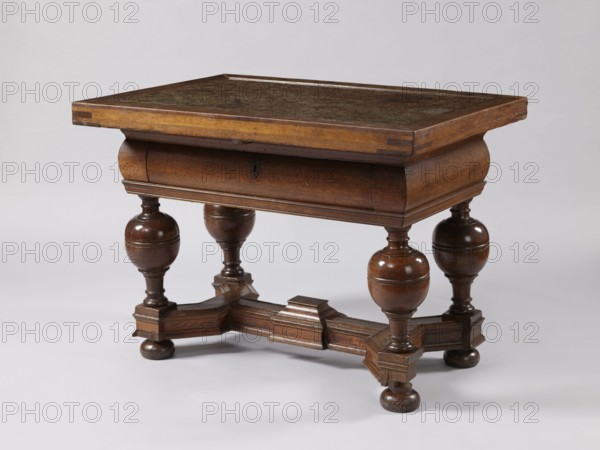 Stock exchange table, provenance unknown, Baroque style, stone tops, rectangular. Rectangular stock exchange table with a stone top enclosed in a wooden frame and a drawer in a high frame, supported by four turned baluster legs joined with an H stretcher made of profiled beams. Baluster legs have massive balls in the upper section, terminating at the bottom with flattened balls. Central section of the stretcher has a rectangular extension with a pinnacle not preserved. Reinforcing parquetry under the top. Applied drawer bottoms with slides. Stone top polished only on the upper surface. Drawer lock plate in the form of a cartouche topped with a lily. Steel mortise-and-slip double-bolt lock. 4th quarter of the 17th century, Royal Prussia possible origin. Furniture, table; height 88.5 cm, width 121.3 cm, depth 90.4 cm., A wooden table with a rectangular top and a raised edge sits against a plain light background, showing a warm brown finish and a darker worn surface on the tabletop; the t...