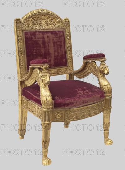 Armchair, ; griffins; Empire style; grotesques ornament; plant decoration; wickerwork ornament; kimation ornament. Straight backrest with a clearance, slightly tilted, topped with a semicircular board. Padded armrests supported by griffins. Trapezoidal seat with high frames front arched. Straight, turned front legs ending in lion paws. Early 19th century, Europe. Piece of furniture, seating piece. Height 108 cm, width 69 cm, depth 54 cm., An ornate armchair with a carved wooden frame finished in gold and upholstered in deep burgundy velvet, showing a rectangular backrest with a decorative crest, padded armrests topped with burgundy cushions, arm supports carved as winged mythic heads, a padded seat cushion, carved apron and fluted legs terminating in paw feet; visible colors include gold and burgundy against a pale gray background.