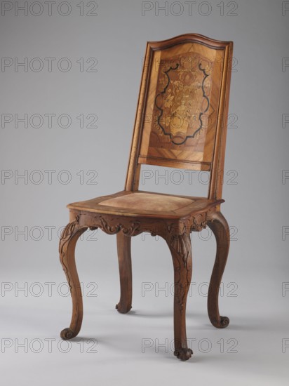 Chair, creator unknown, origin unknown, Rococo style, ca. 1750–1765, Germany. Rococo chair with volute ornament, plant decoration, acanthus, shells, female figures, flowers, and ribbon-and-pincer ornament. Boarded inlaid backrest depicting a lady in a crinoline surrounded by flowers, framed by two intertwining U-shaped ribbons. Rectangular originally upholstered seat supported by cabriole legs; legs decorated in bas-relief with motifs at the top shells on the knees and terminating in volute feet. Frame wavy-cut at the bottom decorated with acanthus leaves. Seat frame with wavy outer outline enclosing a padded central section. High backrest with clearance, angular stiles, and a wavy-curved upper section. Type: piece of furniture seating. Dimensions: height 115 cm, width 53 cm, depth 63 cm., A wooden chair with a high back featuring an inlaid panel decorated with floral and figurative marquetry in lighter and darker shades of brown framed by a curved top rail; the seat has a slightly pad...