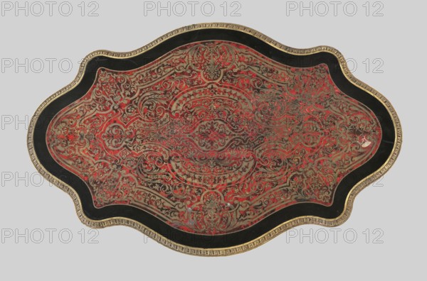 Table, unknown origin, plant decoration, neo-baroque style, plant tendril, female busts, 1870–1880, France, furniture table; height 75.5 cm, width 120.5 cm, depth 77.5 cm, An ornate, curvilinear object with a central decorative field featuring intricate scrolling arabesque patterns in red and metallic gold and silver tones, surrounded by a black border and an outer gilded rim; the design shows symmetrical floral and foliate motifs with dense, interlaced ornamentation and areas of worn patina, with visible contrasts of red, gold, silver, black, and hints of darker brown.